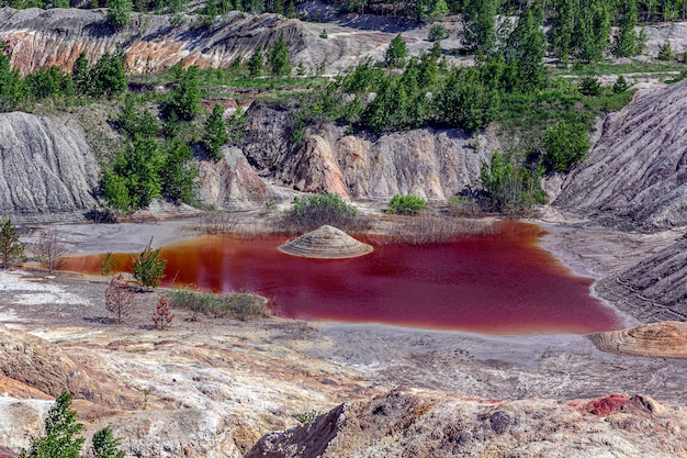 Incredibile paesaggio apocalittico come la superficie di un pianeta Marte. Superficie della Terra nera marrone-rosso solidificata. Terra sterile, incrinata e bruciata. Concetto di riscaldamento globale. Cave di argilla refrattaria.