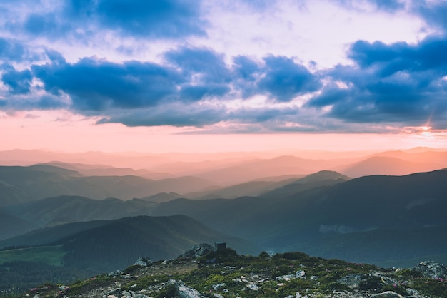 Incredibile paesaggio di montagna con un vivido tramonto colorato sul cielo nuvoloso, sfondo naturale di viaggio all'aperto. Mondo della bellezza.