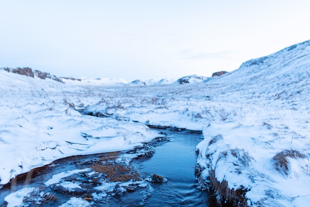 Incredibile paesaggio invernale dell'Islanda. In inverno, una fonte di acqua calda scorre nelle montagne