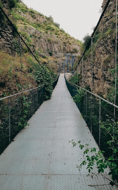 Incredibile ponte sospeso del sentiero della gola tra alte rocce del paesaggio naturale georgia