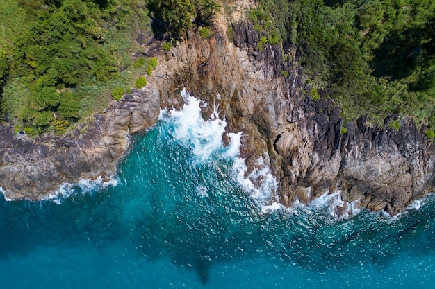 Incredibile vista aerea delle onde del mare che colpiscono rocce con acqua di mare turchese Bellissimo paesaggio marino nella costa dell'isola di Phuket Thailandia Viaggi e tour concept