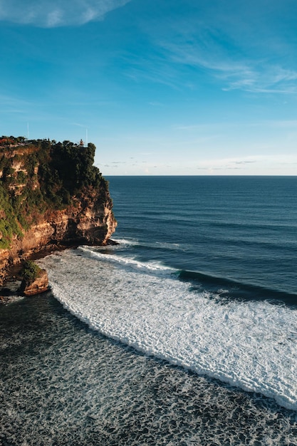 Incredibile vista dell'isola di Bali con la scogliera dell'oceano del cielo blu Destinazione di viaggio estiva Verticale