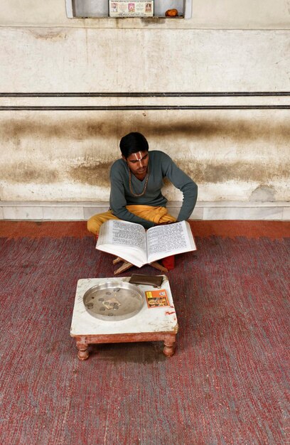 India, Rajasthan, Jaipur; 25 gennaio 2007, ragazzo indiano che legge un libro religioso in un tempio indù vicino al palazzo Sisodia Rani Ka Bagh - EDITORIALE