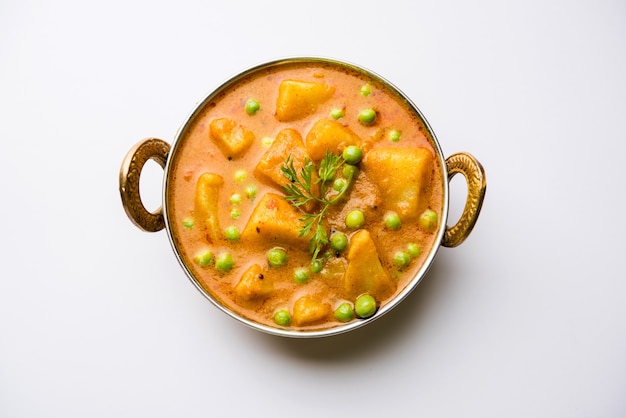 Indian Aloo Mutter curry - Patate e piselli immersi in un sugo di cipolla e pomodoro e guarniti con foglie di coriandolo. Servito in un Karahi o un kadhai o una padella o una ciotola