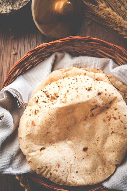 Indian Chapati o Fulka o Gehu Roti con chicchi di grano in background. È un cibo tradizionale dell'India settentrionale o meridionale ricco di fibre sane, messa a fuoco selettiva