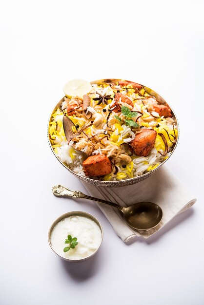 Indian Chicken Tikka Biriyani servito in una ciotola con yogurt. messa a fuoco selettiva