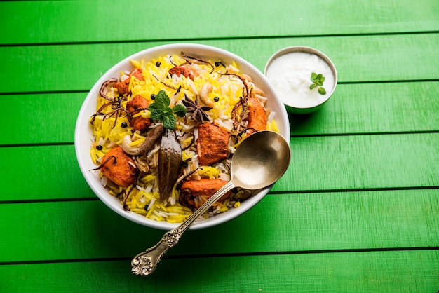 Indian Chicken Tikka Biriyani servito in una ciotola con yogurt. messa a fuoco selettiva