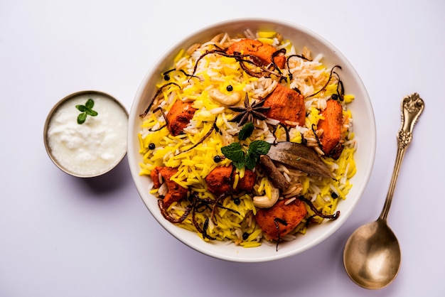 Indian Chicken Tikka Biriyani servito in una ciotola con yogurt. messa a fuoco selettiva