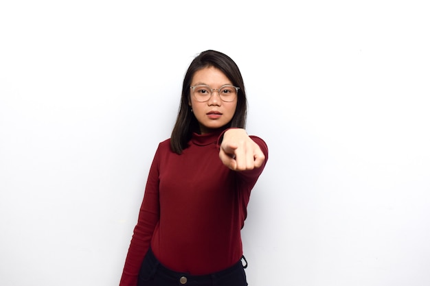 Indicando il tuo gesto di giovani belle donne asiatiche vestono una camicia rossa isolata su sfondo bianco