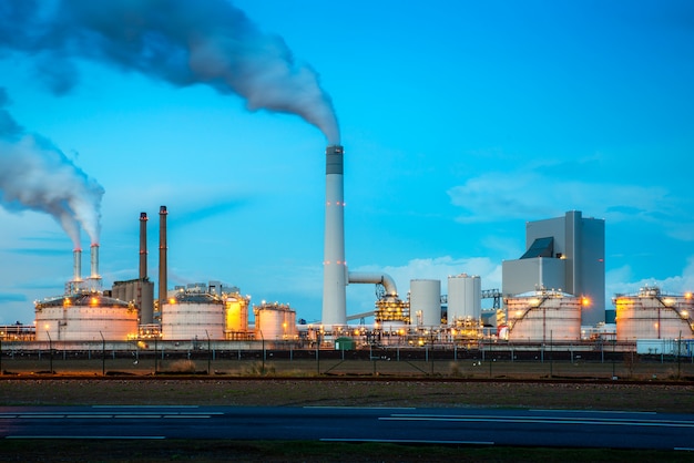 Industria della raffineria di petrolio alla notte a Rotterdam, Paesi Bassi. Fumo di inquinamento dall'industria della raffineria di petrolio.