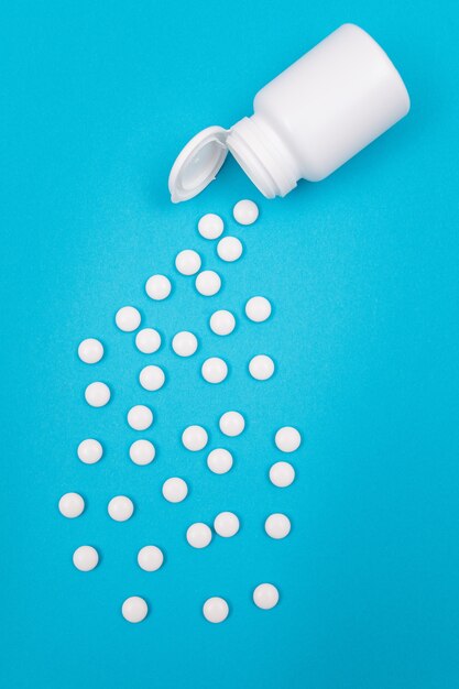 Industria farmaceutica e medicinali pillole bianche su sfondo blu