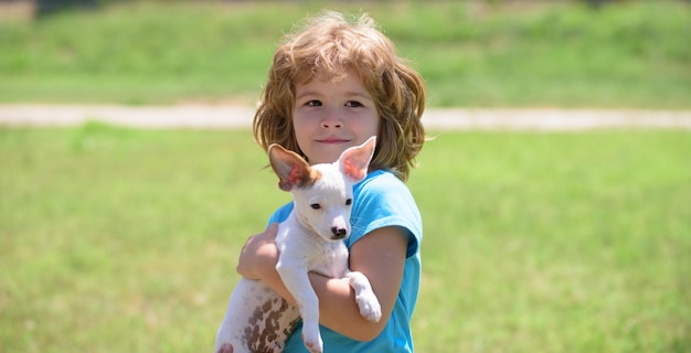 Infanzia felice. Bambini carini con un cucciolo di cane, estate all'aperto. Animali domestici, cura degli animali domestici.