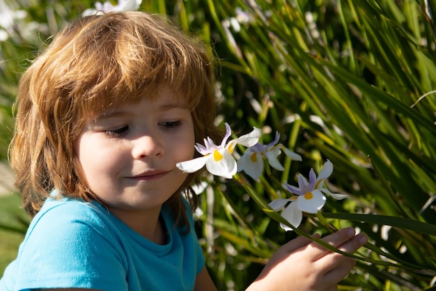 Infanzia felice L'allergia ai bambini di primavera annusa i fiori in fiore Bambino carino nel giardino dei fiori