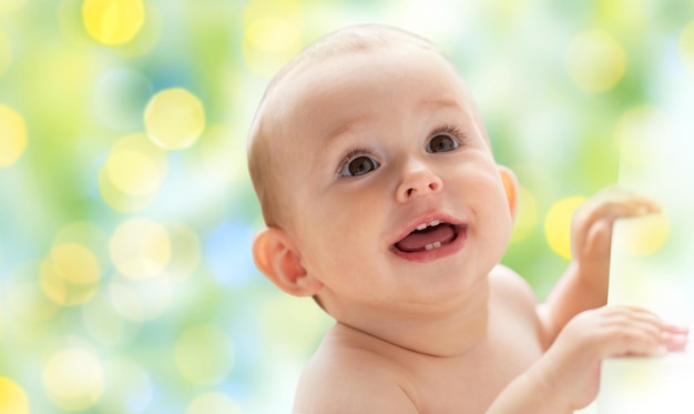 infanzia, infanzia, emozioni e persone concetto - felice piccolo bambino ragazzo o ragazza guardando su oltre le vacanze verdi luci sullo sfondo