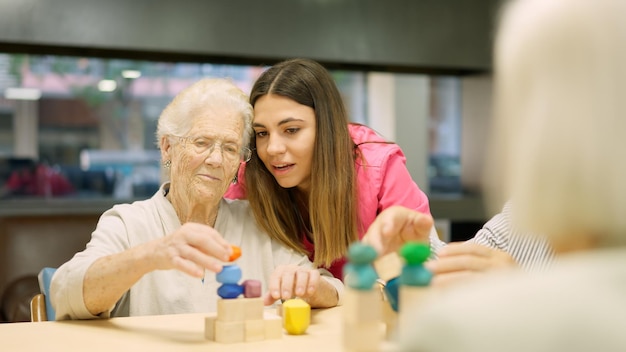 Infermiera che consiglia a una vecchia di risolvere un gioco di abilità