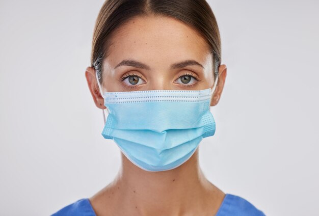 Infermiera di studio e donna con il pollice in alto ritratto e maschera per la sicurezza sì e grazie per l'assistenza sanitaria background medico bianco e persona in mockup professionale e sano in clinica ed esperto