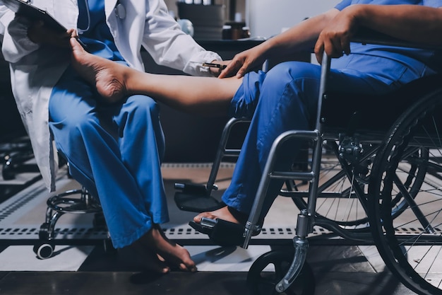 Infermiera fisioterapeuta che esegue la fisioterapia per riabilitare la gamba di una paziente anziana