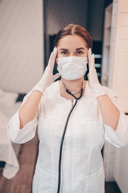 Infermiera medico donna che indossa maschera protettiva e stetoscopio per controllo respirazione, prevenzione del virus corona, igiene per fermare la diffusione del coronavirus. Evitare di contaminare il concetto di Covid-19 del virus Corona