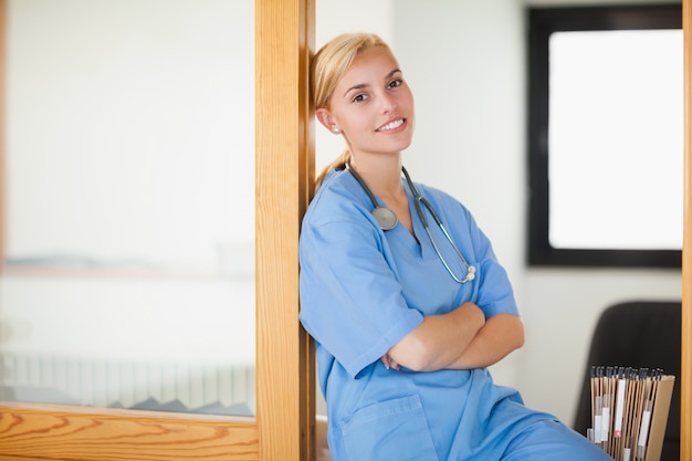 Infermiera sorridente che si siede con le braccia incrociate