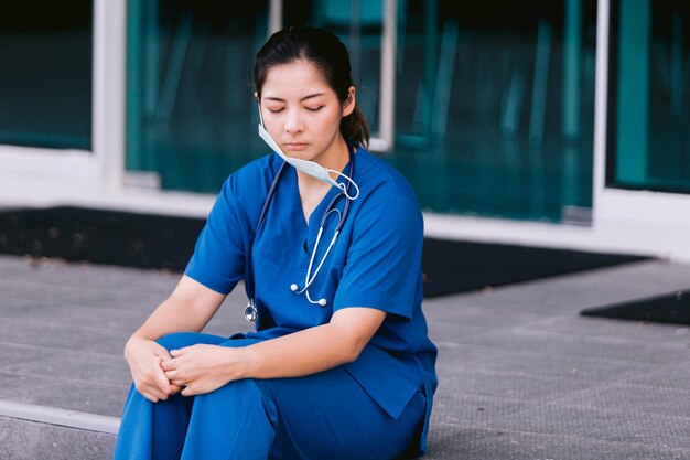 Infermiera stressata seduta nel corridoio dell'ospedale