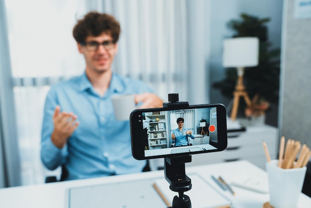 Influencer che presenta la promozione della coppa sul telefono immagine di messa a fuoco con Gusher sfocato