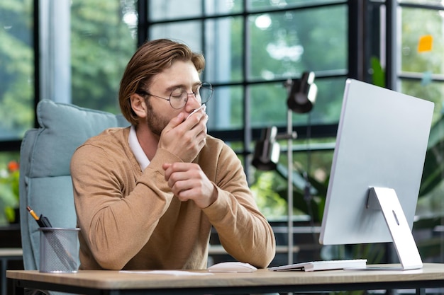 Influenza coronavirus sul posto di lavoro un giovane libero professionista un programmatore lavora in ufficio presso a