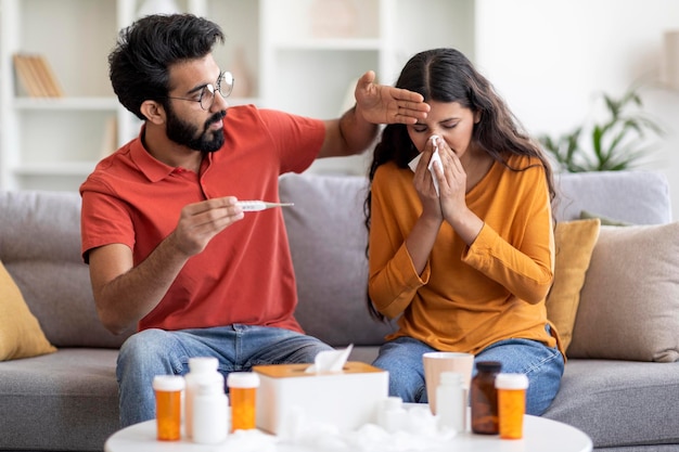 Influenza e raffreddore uomo indiano che si prende cura della moglie malata a casa