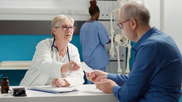 Informazioni mediche per il controllo della scrittura su carta di prescrizione per somministrare medicinali per il trattamento a un pensionato all'appuntamento medico. Prendere appunti sul rapporto di consultazione, sui risultati della diagnosi.