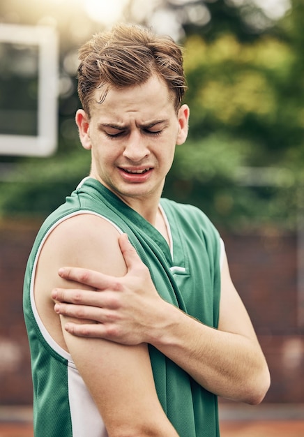 Infortunio muscolare basket o dolore sportivo e uomo con incidente di emergenza al braccio durante il gioco su un campo all'aperto Atleta professionista con problemi medici durante l'allenamento e l'esercizio per la partita sportiva