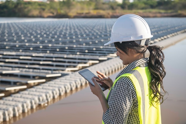 Ingegnere asiatico che lavora presso la fattoria solare galleggianteEnergia rinnovabileTecnico e investitore di pannelli solari che controllano i pannelli nell'installazione di energia solare