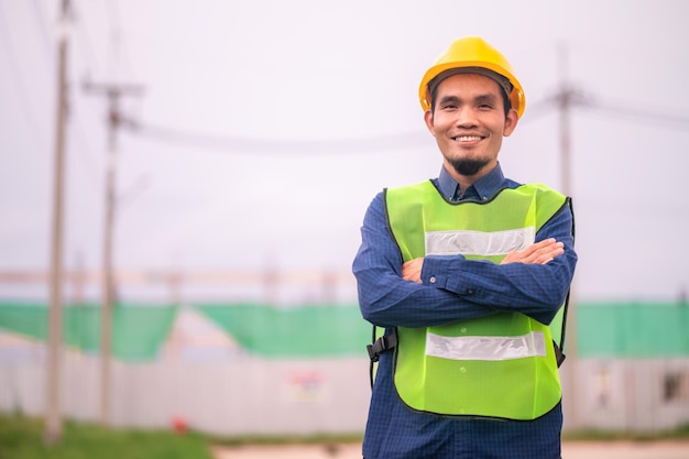 Ingegnere asiatico in piedi all'aperto sul sito di costruzione che pubblica fiducioso Ingegnere nella costruzione di un lavoro felice con successo nella pianificazione dell'obiettivo