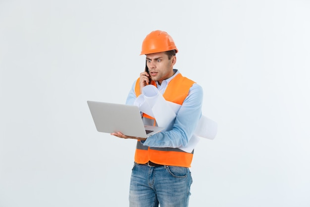 Ingegnere bello deluso che indossa giubbotto arancione e jeans con casco, isolato su sfondo bianco.