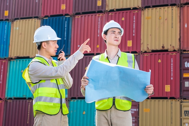 Ingegnere che controlla il contenitore di carico di carico dall'esportazione di importazione di navi da carico