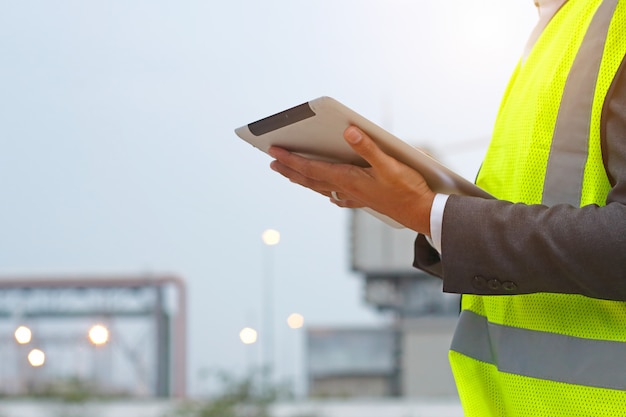 Ingegnere che lavora alla tavoletta di controllo all&#39;aperto sul cantiere