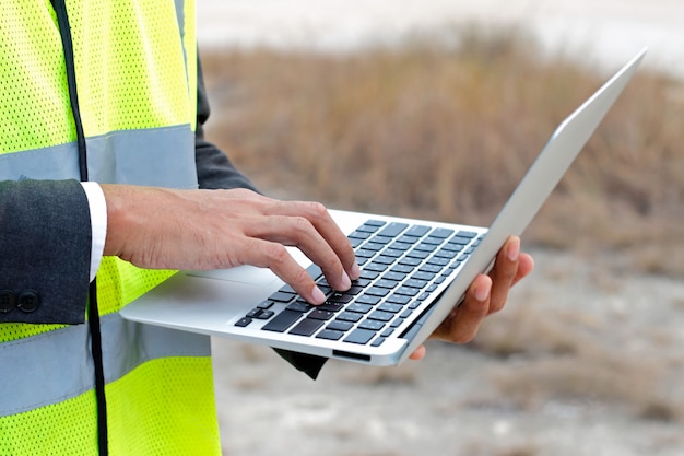 Ingegnere che lavora con il computer portatile sul cantiere