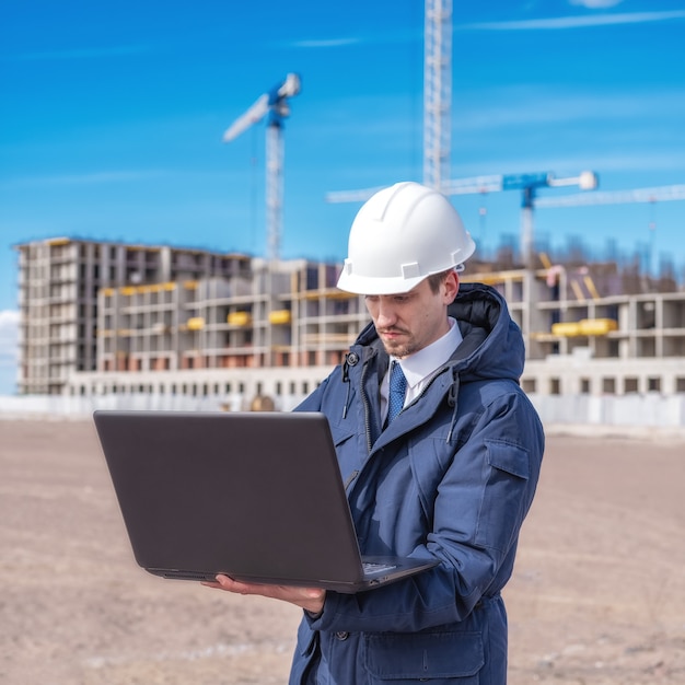 Ingegnere civile in un casco bianco alla ricerca di documenti sulla costruzione