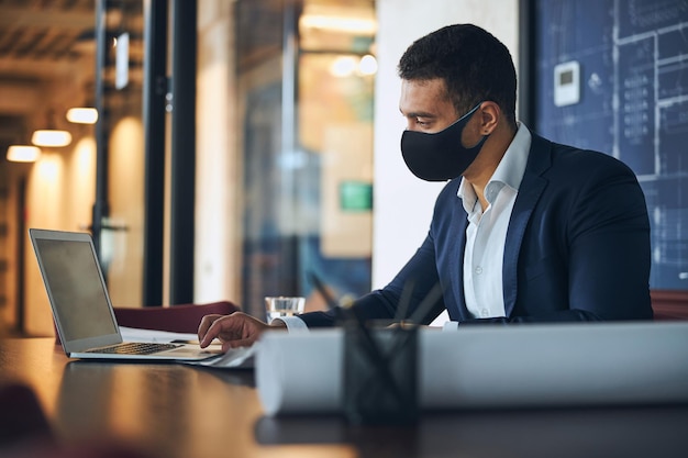 Ingegnere dai capelli scuri che utilizza il computer sul posto di lavoro