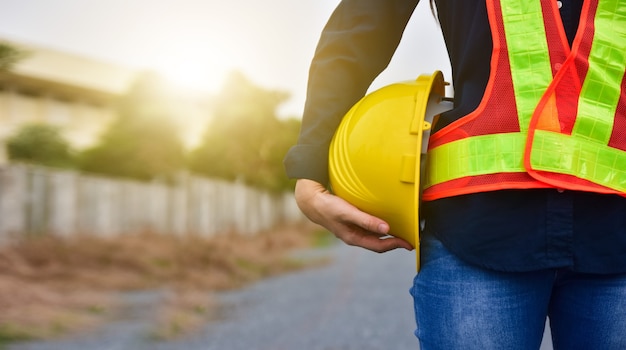 Ingegnere della donna che tiene il casco fuori dalla costruzione del sito della porta