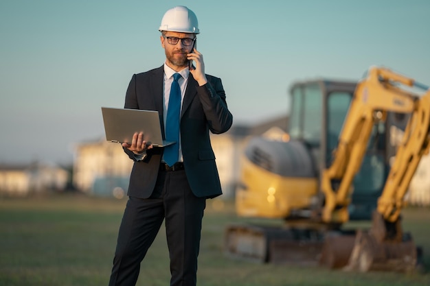 Ingegnere di costruzione o ingegnere civile lavoratore in un cantiere di costruzione ingegnere lavoratore in tuta e casco