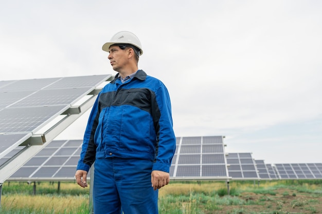 Ingegnere di servizio uomo in piedi di fronte ai pannelli solari tecnico di manutenzione delle celle solari su solare