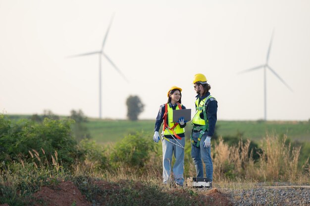 Ingegnere e operaio discutono su un parco di turbine eoliche con i progetti