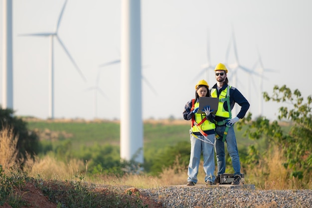 Ingegnere e operaio discutono su un parco di turbine eoliche con i progetti