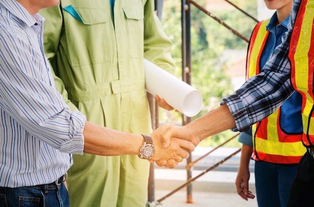 ingegnere e tecnico che agitano mano nel cantiere