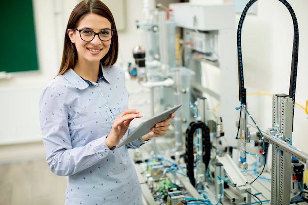 Ingegnere elettronico femminile che utilizza compressa digitale in laboratorio