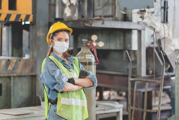 Ingegnere femminile asiatico che indossa maschera protettiva e casco