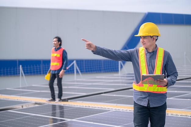 Ingegnere fiducioso che controlla l'energia solare presso la fabbrica sul tetto