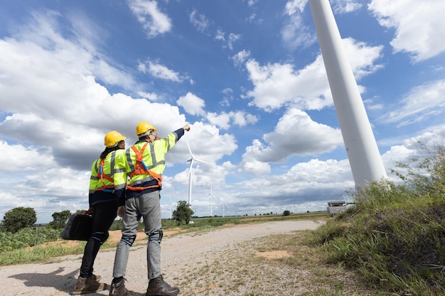 Ingegnere ingegnere di turbine eoliche tecnico maschio che lavora in squadra servizio manutenzione indagine cantiere di costruzione generatore di energia ecologica per persone sostenibili lavoratore