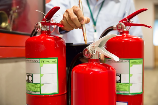 Ingegnere ispezione Estintore nella sala controllo incendi.