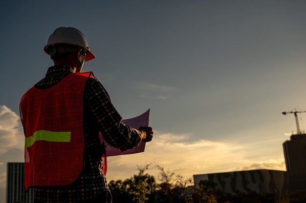 ingegnere maschio che lavora in cantiere all'ora di Silhouette Sunset