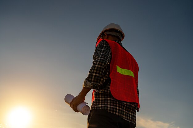 ingegnere maschio che lavora in cantiere all'ora di Silhouette Sunset